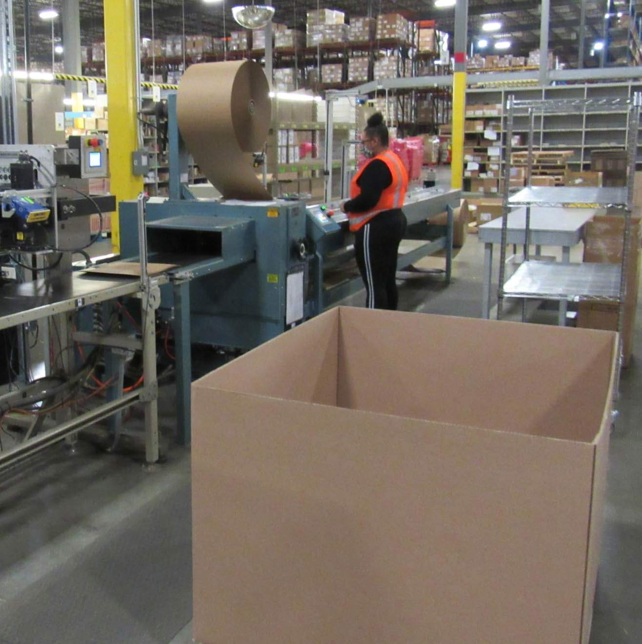 Employees prepare cardboard boxes in preparation for shipping